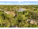 Aerial view showcasing the home's proximity to a lake and surrounded by mature trees at 8800 Torey Pines Ter, Orlando, FL 32819