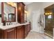 Bathroom boasts a dual vanity, granite countertops, and a glass-enclosed shower at 8800 Torey Pines Ter, Orlando, FL 32819
