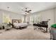 Spacious bedroom featuring two windows, a ceiling fan, and carpeted floors, offering comfort and ample natural light at 8800 Torey Pines Ter, Orlando, FL 32819