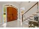Bright foyer features a grand wooden front door, tile flooring, and a staircase at 8800 Torey Pines Ter, Orlando, FL 32819