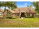 Charming brick home features a well-manicured lawn, mature trees, and a welcoming front entrance at 8800 Torey Pines Ter, Orlando, FL 32819