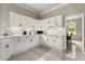 A bright kitchen with white cabinets and tile flooring offering a clean, modern look with backyard views at 8800 Torey Pines Ter, Orlando, FL 32819