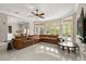 Bright living room features a leather sectional couch, large windows, and tile flooring at 8800 Torey Pines Ter, Orlando, FL 32819
