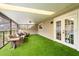 Inviting covered patio with turf flooring and comfortable seating area, perfect for relaxation at 8800 Torey Pines Ter, Orlando, FL 32819