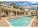 Beautiful backyard with a screened-in pool, brick patio, and ample seating for outdoor enjoyment at 8800 Torey Pines Ter, Orlando, FL 32819
