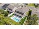 Aerial view of backyard featuring a pool with modern patio furniture and artificial turf accents at 9224 Legado Dr, Windermere, FL 34786