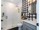 Updated bathroom features a glass-enclosed shower, modern vanity, and decorative buffalo check wallpaper at 9224 Legado Dr, Windermere, FL 34786