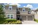 Close up of a two-story home with two car garage with paver driveway and beautiful front landscaping at 9224 Legado Dr, Windermere, FL 34786