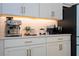 Kitchenette area showcases countertop appliances on white cabinetry with gold hardware at 9224 Legado Dr, Windermere, FL 34786