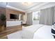 Bright main bedroom featuring wood floors, decorative wood wall, large windows, and a spacious closet at 9224 Legado Dr, Windermere, FL 34786