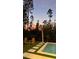 Relaxing pool area with Adirondack chairs and a convenient outdoor shower surrounded by trees at 9224 Legado Dr, Windermere, FL 34786