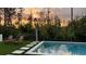 Inviting pool with lounge chairs, stepping stones, outdoor shower, and gorgeous nature view in the background at 9224 Legado Dr, Windermere, FL 34786