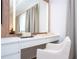Elegant vanity area featuring a well lit mirror, sleek surfaces and a comfortable chair at 9224 Legado Dr, Windermere, FL 34786