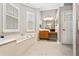 Elegant bathroom showcasing a soaking tub, plantation shutters, and vanity area at 9880 Montclair Cir, Apopka, FL 32703