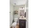 A well-lit powder room with modern vanity, decorative shelf, and neutral wall color at 9880 Montclair Cir, Apopka, FL 32703