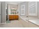 Bright bathroom featuring a soaking tub, separate shower, and dual sink vanity at 9880 Montclair Cir, Apopka, FL 32703