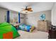 Bright bedroom features ceiling fan, carpet, window, theme, and blue curtains at 9880 Montclair Cir, Apopka, FL 32703