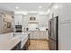 Bright kitchen with white cabinetry, stainless steel refrigerator, and modern countertops at 9880 Montclair Cir, Apopka, FL 32703