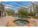 Lush, landscaped screened pool area with spa and rock features at 9880 Montclair Cir, Apopka, FL 32703