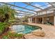 Backyard oasis featuring a screened pool and waterfall feature at 9880 Montclair Cir, Apopka, FL 32703