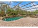 Resort-style screened-in pool area with rock waterfall and tropical landscaping at 9880 Montclair Cir, Apopka, FL 32703