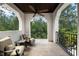 Relaxing balcony with comfortable seating overlooking lush green trees and wrought iron railings at 10138 Enchanted Oak Dr, Golden Oak, FL 32836