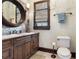 Traditional bathroom features a wood vanity with a marble countertop and a decorative oval mirror at 10138 Enchanted Oak Dr, Golden Oak, FL 32836