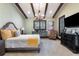 Serene bedroom with beamed ceilings, ample natural light, and stylish furnishings create a cozy retreat at 10138 Enchanted Oak Dr, Golden Oak, FL 32836