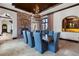 Elegant dining room featuring a brick fireplace, a large chandelier, and comfortable seating at 10138 Enchanted Oak Dr, Golden Oak, FL 32836