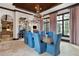 Stylish dining room with rustic wood table, blue upholstered chairs, and contemporary chandelier at 10138 Enchanted Oak Dr, Golden Oak, FL 32836