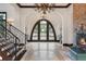 Spacious foyer boasting decorative tile flooring, grand archway, wrought iron staircase, and brick fireplace at 10138 Enchanted Oak Dr, Golden Oak, FL 32836