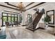 Open foyer showcasing a staircase with decorative ironwork, travertine tile flooring, chandelier, and views to outdoor pool area at 10138 Enchanted Oak Dr, Golden Oak, FL 32836