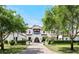 Stunning front exterior featuring a beautiful Spanish roof, mature landscaping, and a paver driveway at 10138 Enchanted Oak Dr, Golden Oak, FL 32836
