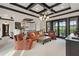 Bright living room with coffered ceilings, comfortable seating, and access to a balcony at 10138 Enchanted Oak Dr, Golden Oak, FL 32836
