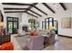 Spacious living room featuring a stone fireplace, beamed ceiling, and abundant natural light at 10138 Enchanted Oak Dr, Golden Oak, FL 32836