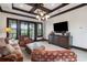 Living room features coffered ceilings, large windows, comfortable seating and a mounted TV at 10138 Enchanted Oak Dr, Golden Oak, FL 32836