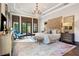 Elegant main bedroom featuring a crystal chandelier, French doors, and a cozy sitting area at 10138 Enchanted Oak Dr, Golden Oak, FL 32836