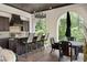 Inviting outdoor kitchen with a grill, bar seating, stone countertops, and picturesque backyard views at 10138 Enchanted Oak Dr, Golden Oak, FL 32836