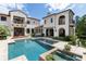 Rear view of an estate showcasing a large pool, manicured landscaping, and covered patio at 10138 Enchanted Oak Dr, Golden Oak, FL 32836