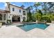 Gorgeous backyard with a sparkling swimming pool, spa, and covered patio area with lounge chairs at 10138 Enchanted Oak Dr, Golden Oak, FL 32836