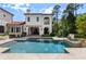 Expansive pool and spa area with travertine deck, and covered patio for relaxing by the water at 10138 Enchanted Oak Dr, Golden Oak, FL 32836