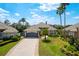 Aerial view of a beautiful home with a well-maintained lawn, tiled roof, and brick driveway at 10662 Woodchase Cir, Orlando, FL 32836
