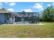 Lawn featuring screened in pool and backyard at 10662 Woodchase Cir, Orlando, FL 32836