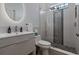 Modern bathroom with a glass shower, decorative tiles, floating vanity, and an illuminated circular mirror at 10662 Woodchase Cir, Orlando, FL 32836