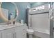 Bright bathroom featuring an oversized mirror, marble vanity, and shower/tub combo with a blue tile accent at 10662 Woodchase Cir, Orlando, FL 32836