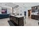 Open kitchen featuring island with sink, seating, modern appliances, and view to the living area at 10662 Woodchase Cir, Orlando, FL 32836