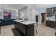 Open kitchen with island seating, modern appliances, and view to the living area at 10662 Woodchase Cir, Orlando, FL 32836