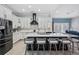 Bright kitchen with large island, breakfast bar seating, stainless steel appliances, and white cabinets at 10662 Woodchase Cir, Orlando, FL 32836