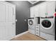 Contemporary laundry room with modern washer and dryer units and white cabinetry at 10662 Woodchase Cir, Orlando, FL 32836
