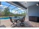 Screened in patio with outdoor table and chairs overlooking the private pool at 10662 Woodchase Cir, Orlando, FL 32836